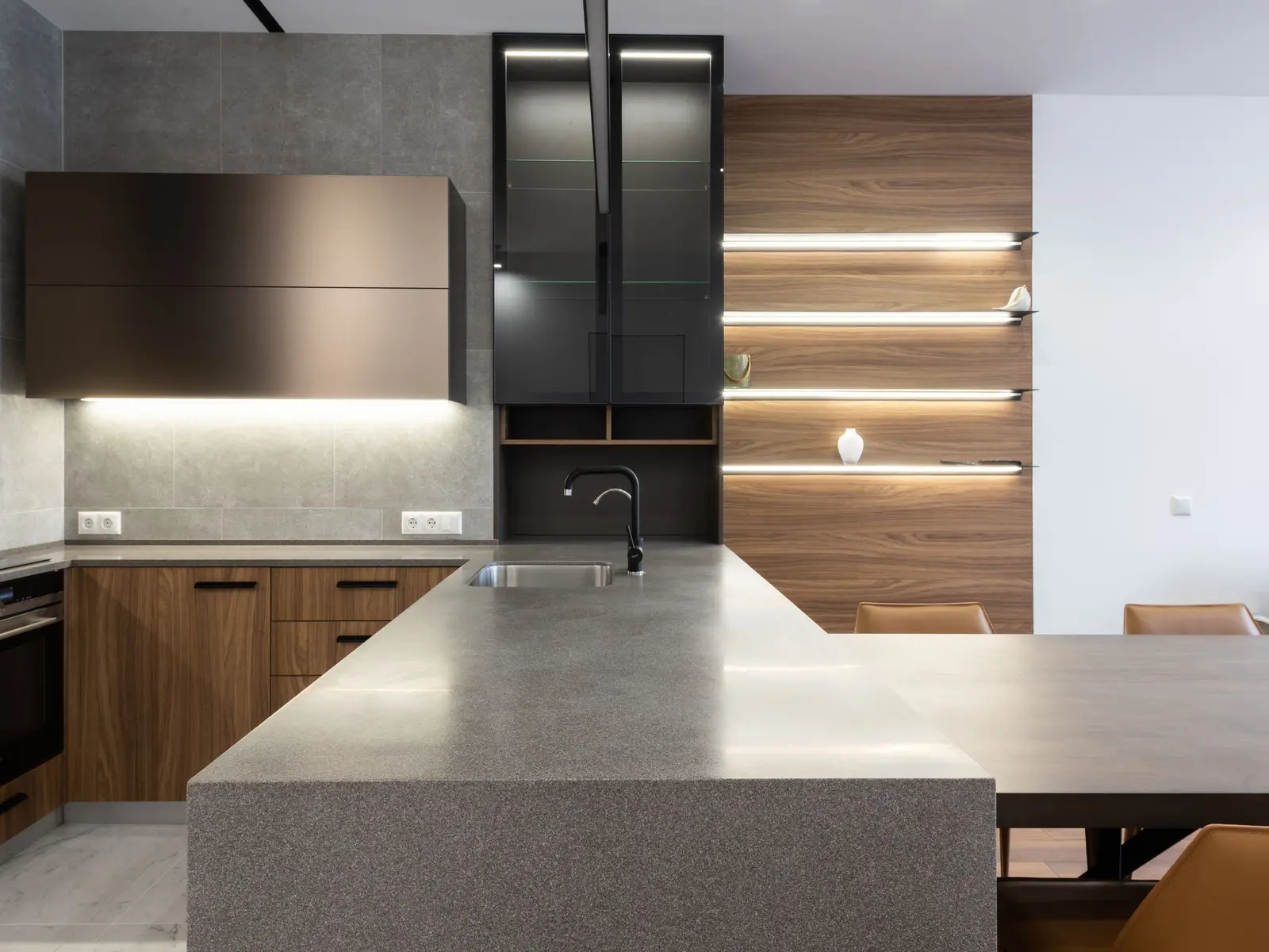 Îlot de cuisine moderne au plan de travail sombre et mat, façades en bois