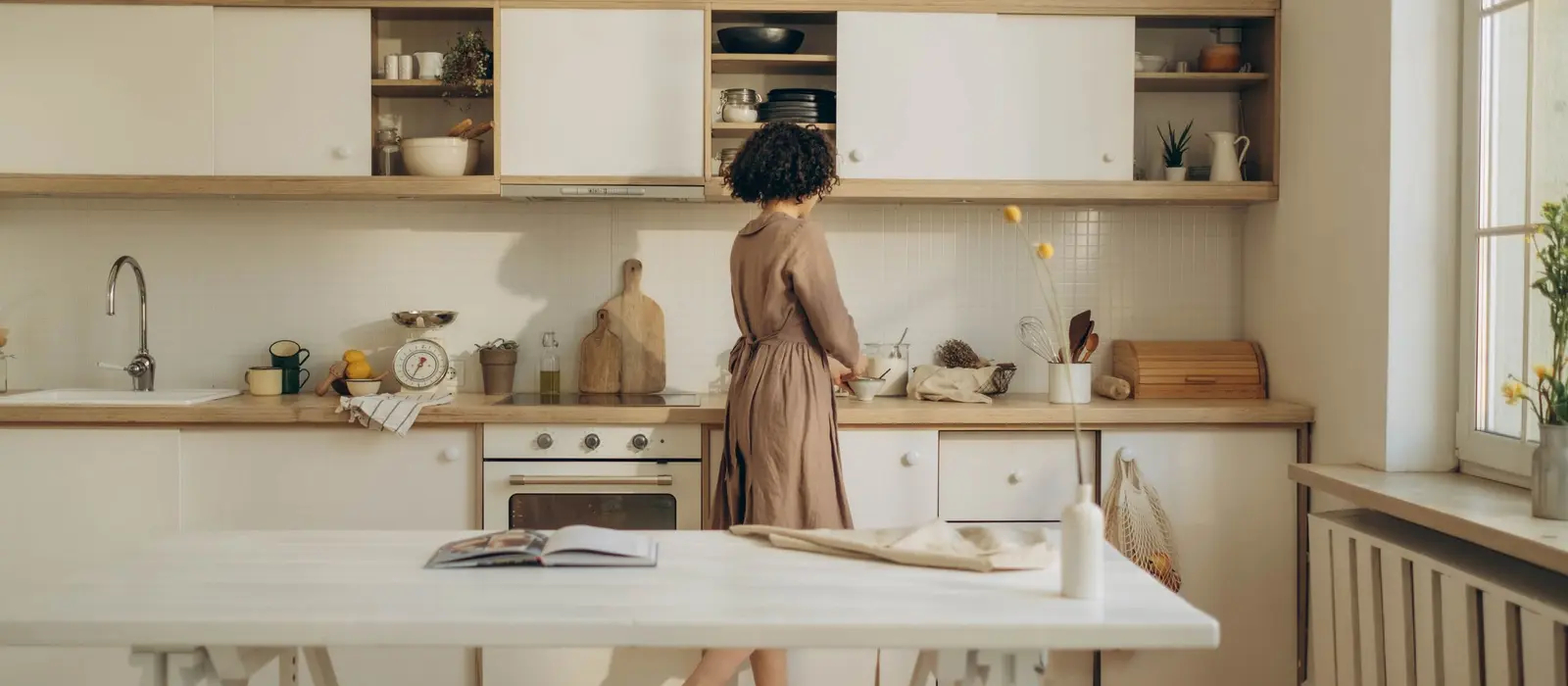 Cuisine claire aux meubles bas et étagères ouvertes, plan de travail dégagé