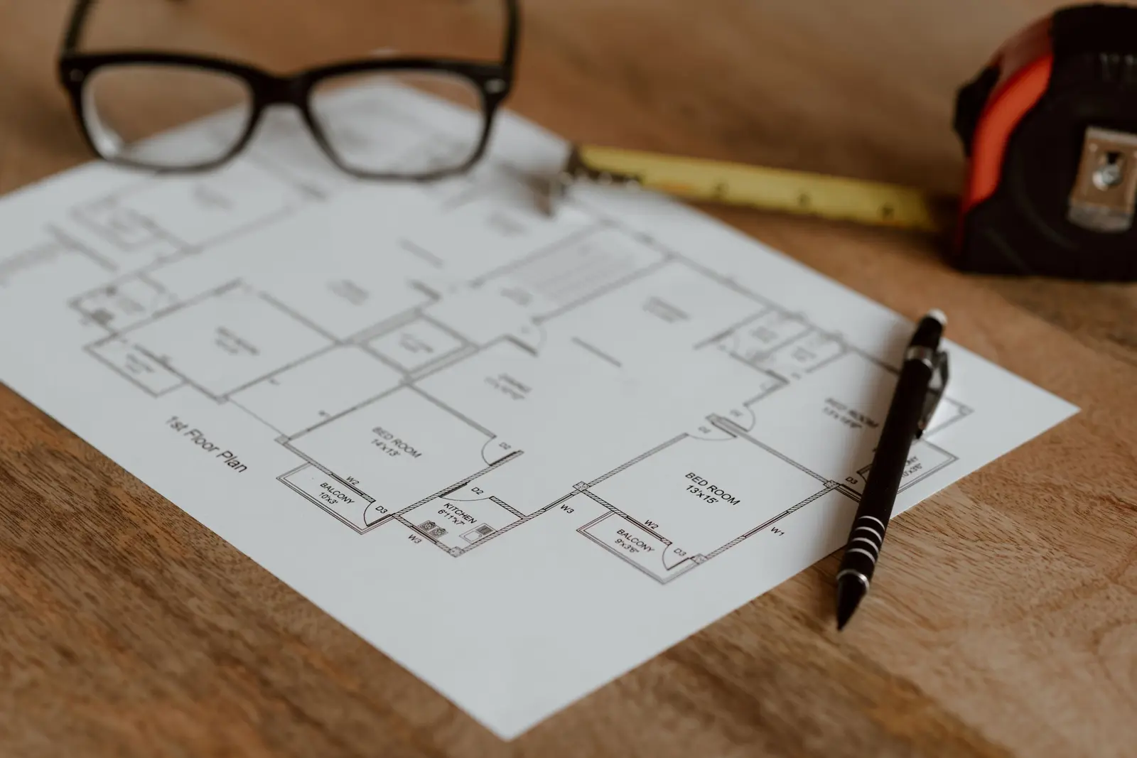 Plan d'appartement, lunettes, crayon et mètre ruban sur un bureau