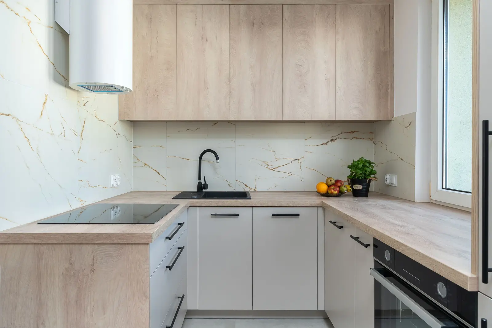 Plan de travail dégagé entre l'évier et la table de cuisson dans une cuisine compacte