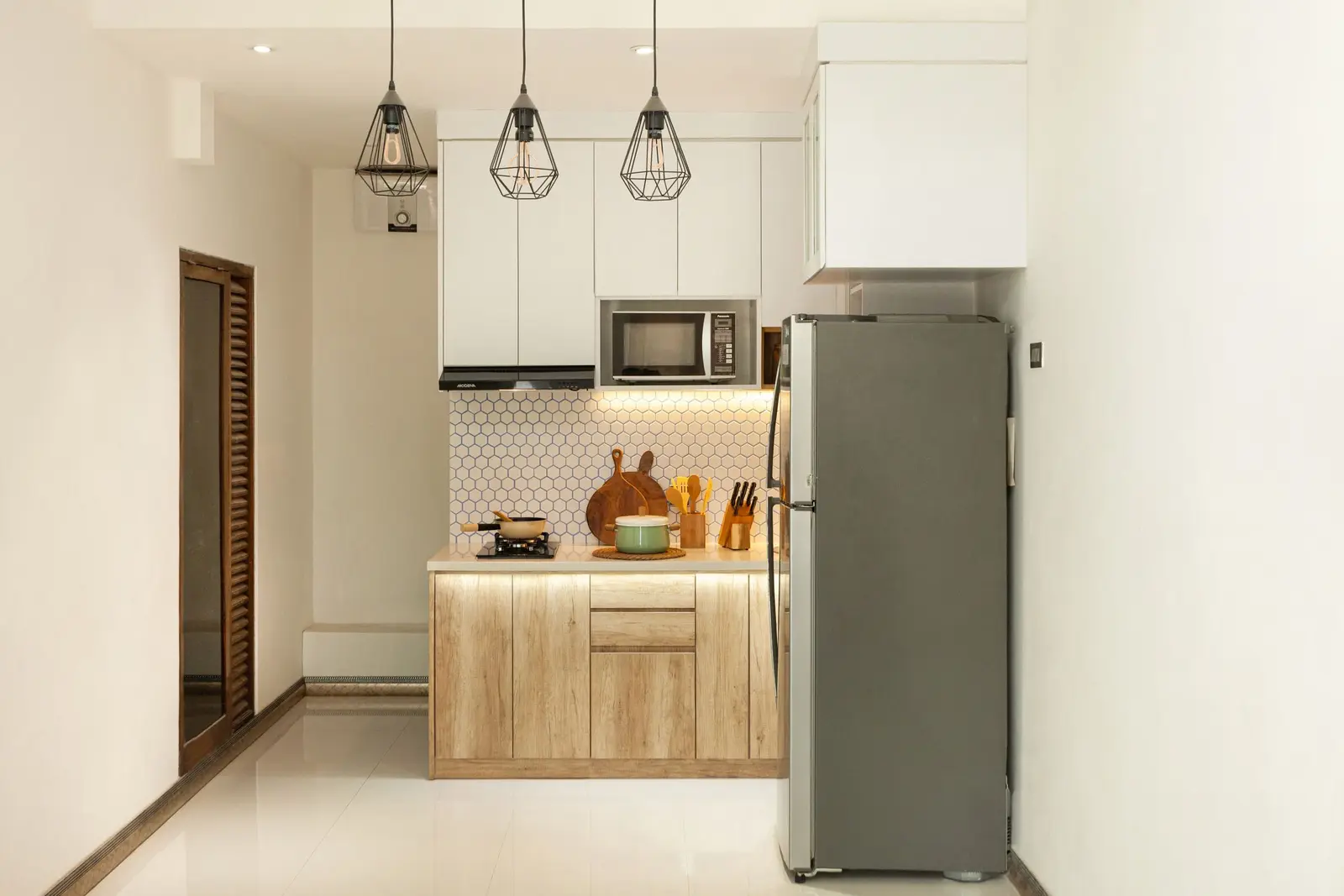 Petite cuisine avec colonne haute, meubles suspendus et suspensions