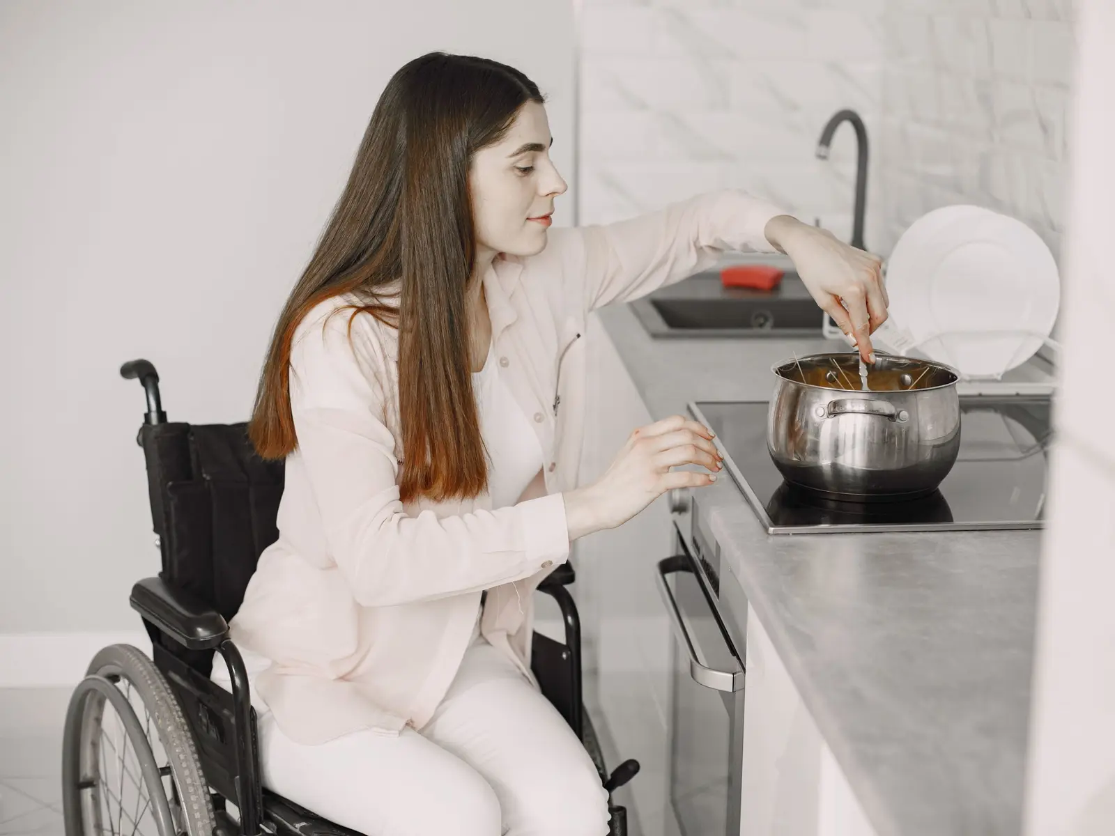 Personne en fauteuil roulant cuisinant devant un plan de travail accessible