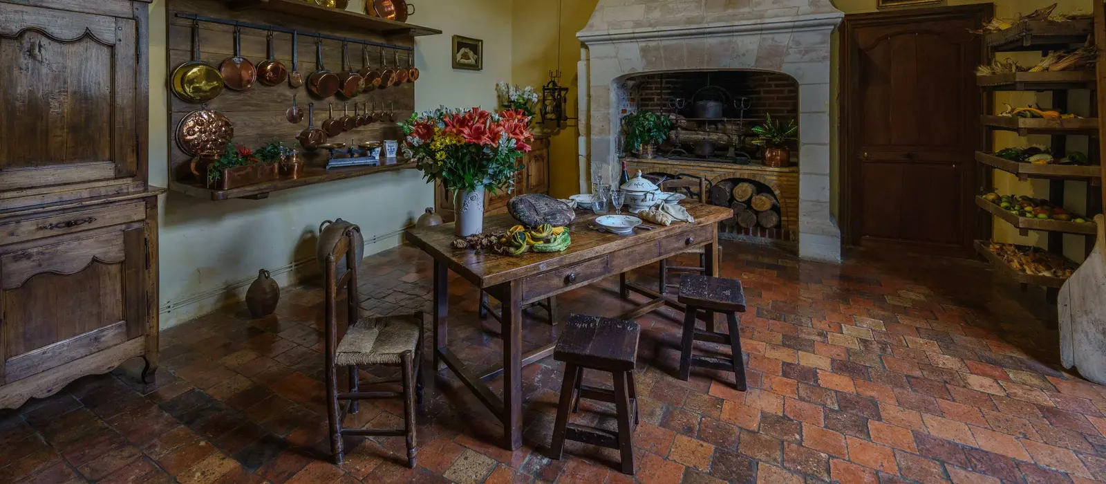 Cuisine de maison ancienne, sol en terre cuite et cheminée en pierre