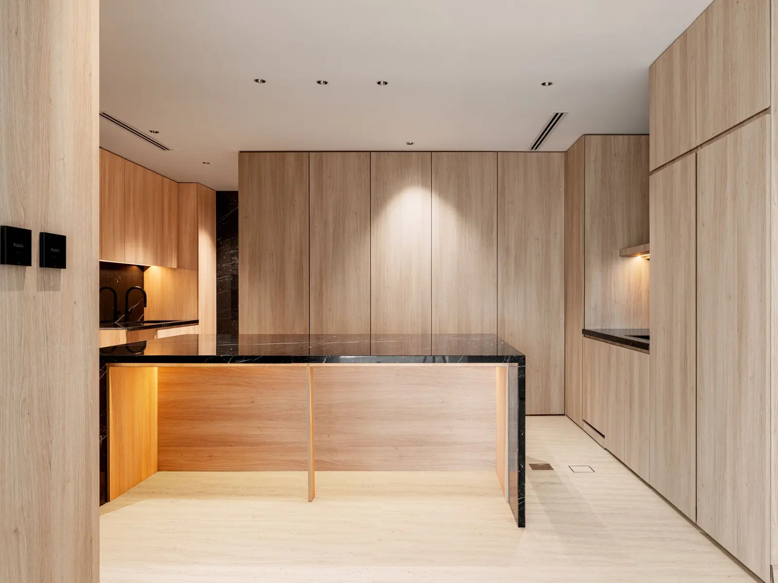 Cuisine moderne aux façades en bois sans poignée, avec un îlot