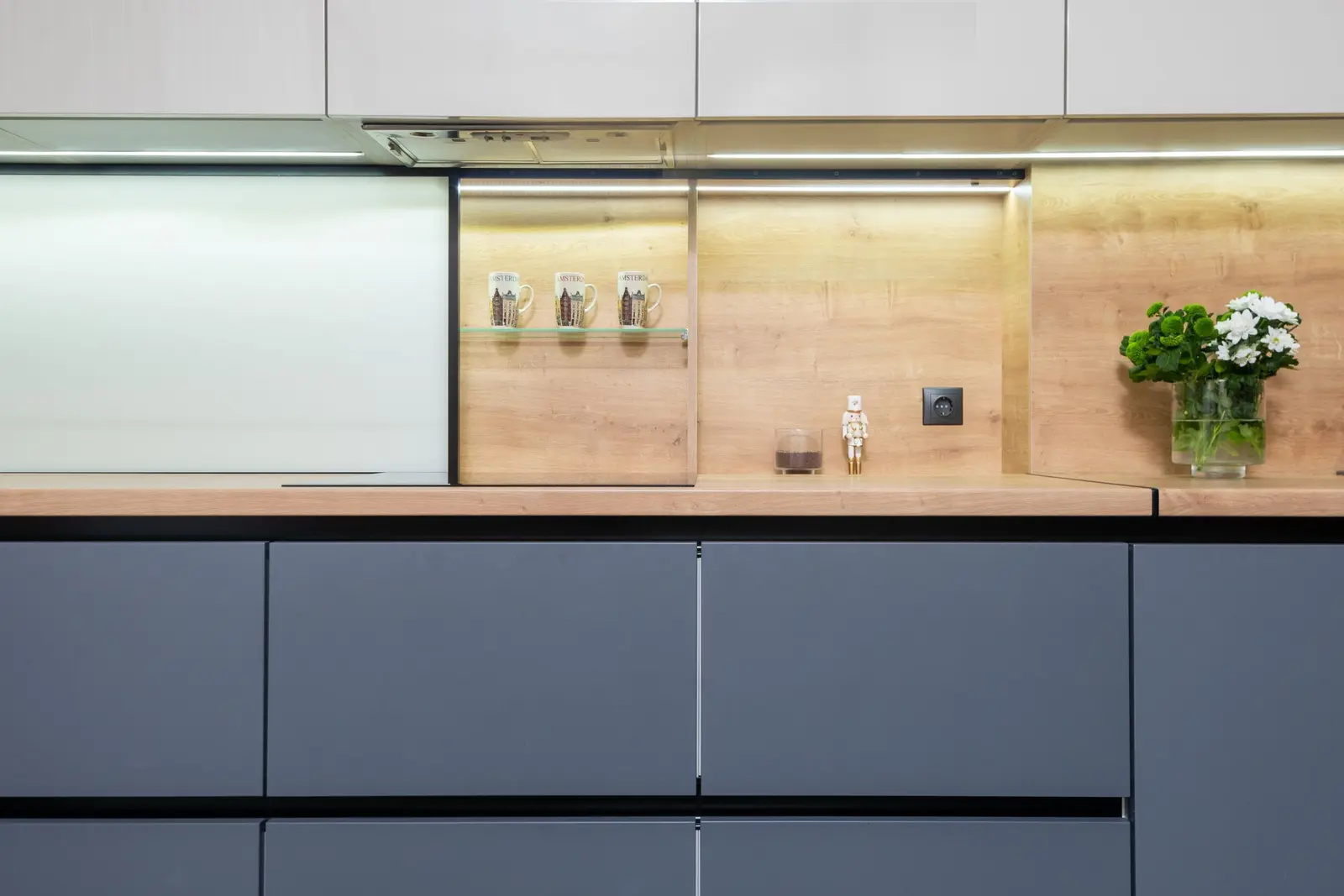 Gros plan sur une gorge en aluminium au-dessus de façades de cuisine sans poignée