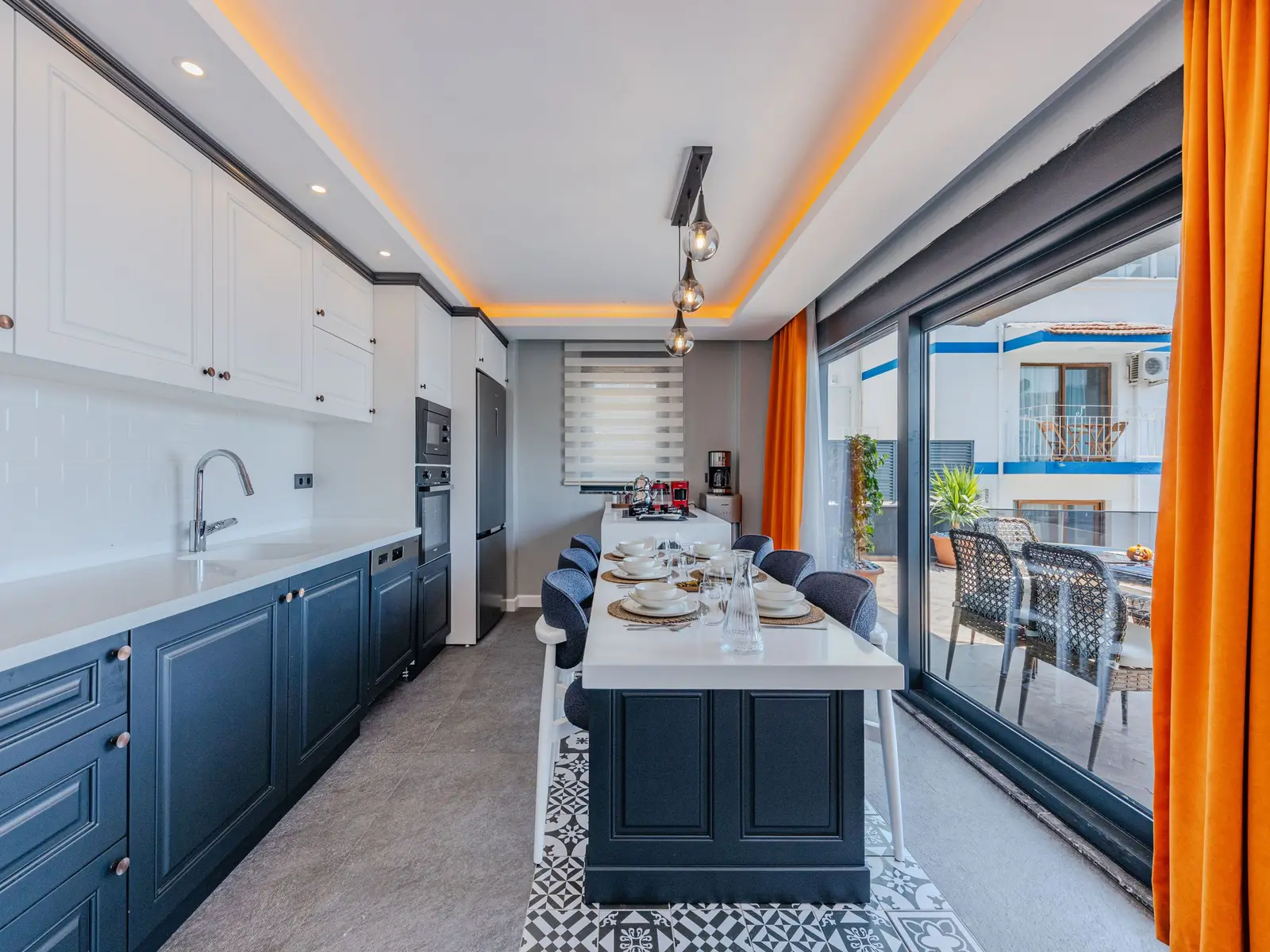 Cuisine en longueur ouverte sur une terrasse par une grande baie vitrée