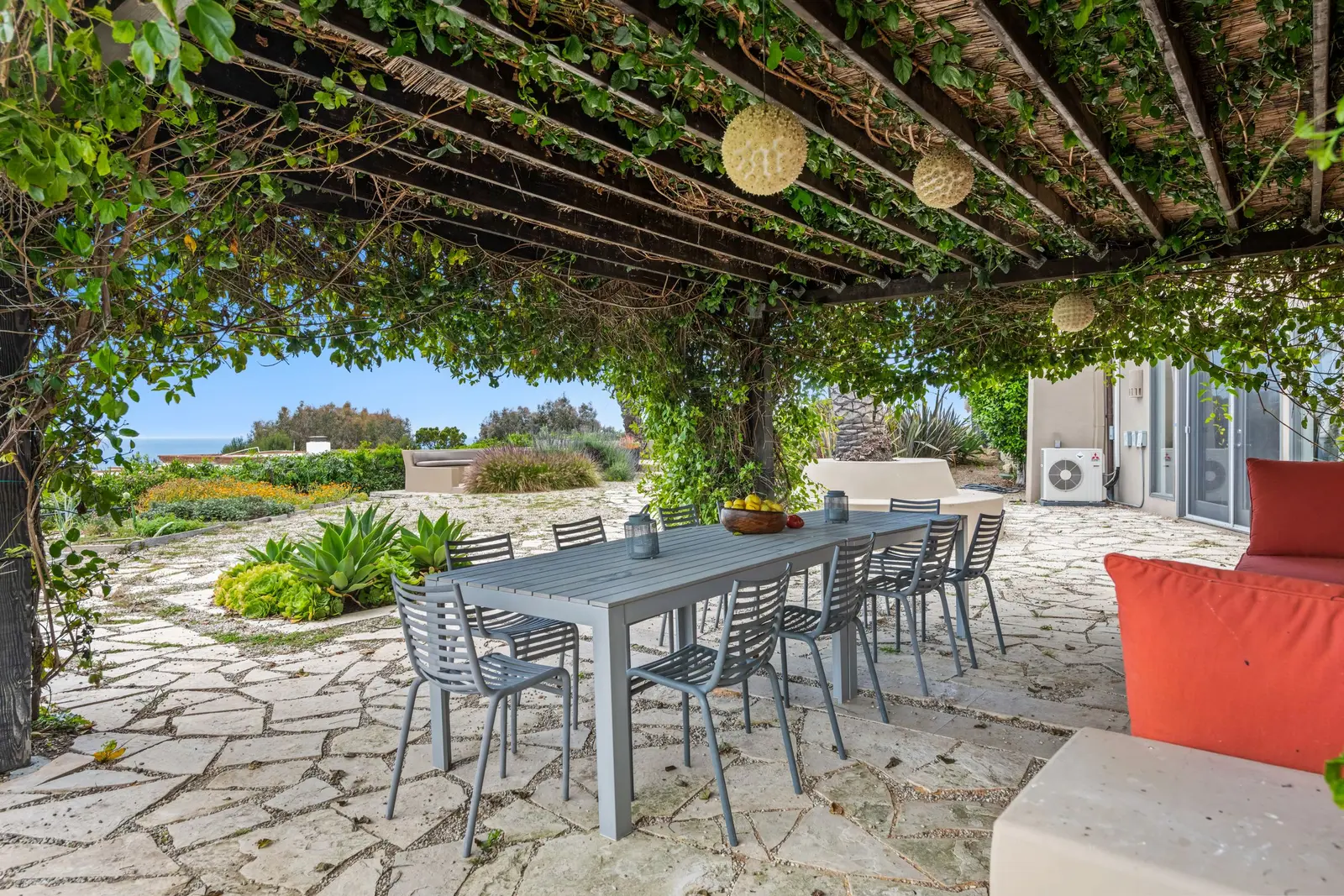 Terrasse ombragée par une pergola végétalisée, table de repas en plein air