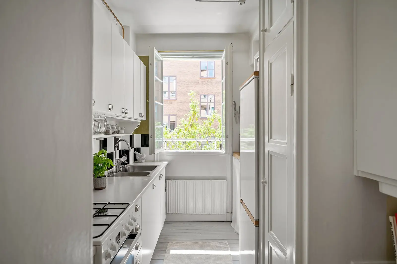Cuisine en longueur dans un appartement ancien, éclairée par une seule fenêtre
